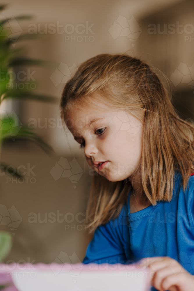 Young girl in superhero costume making an artwork. - Australian Stock Image