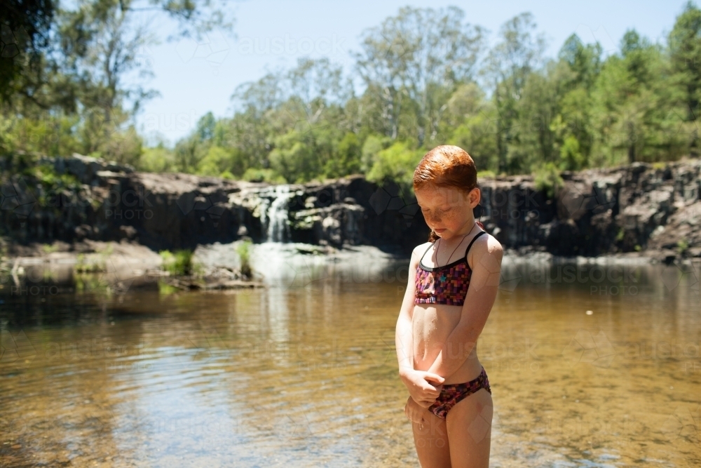 Young girl in swimmers at a waterfall - Australian Stock Image