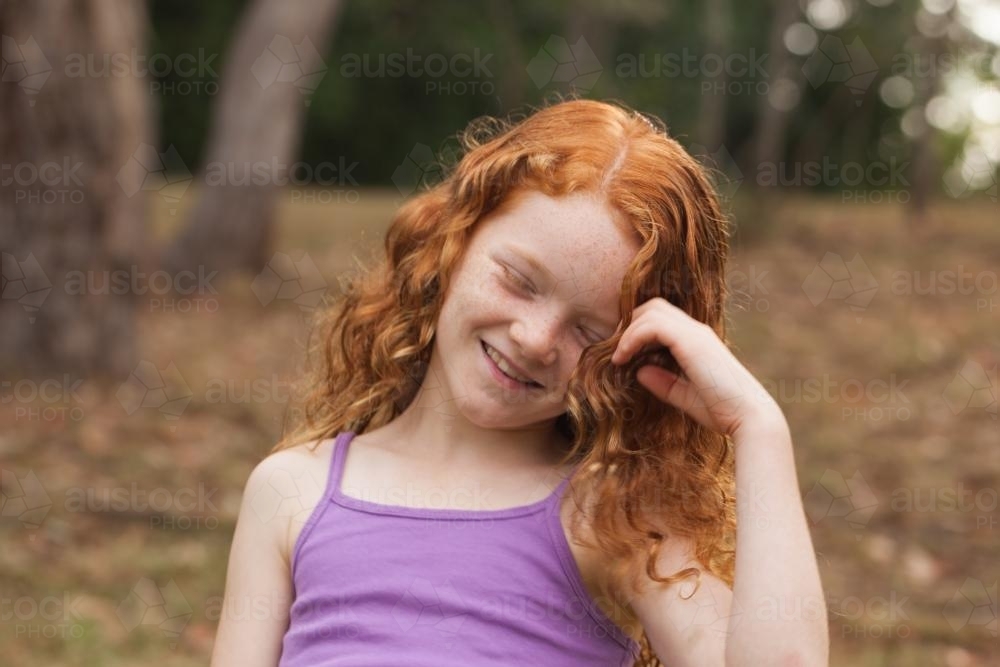 Young girl laughing in an open field : Austockphoto Young girl laughing in an open field - Australian Stock Image
