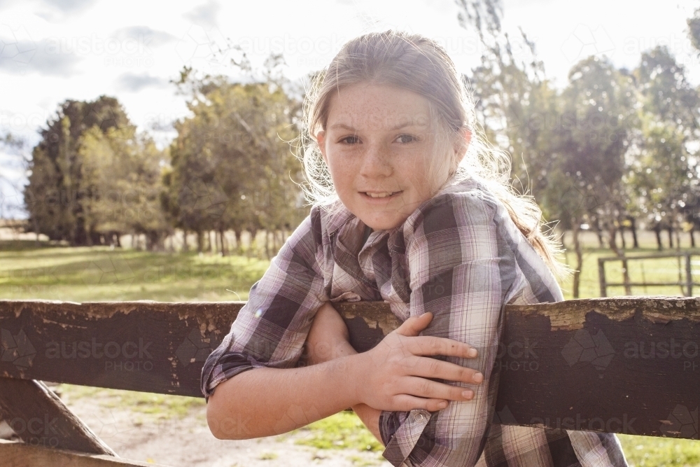 Young girl leaning over a fence - Australian Stock Image