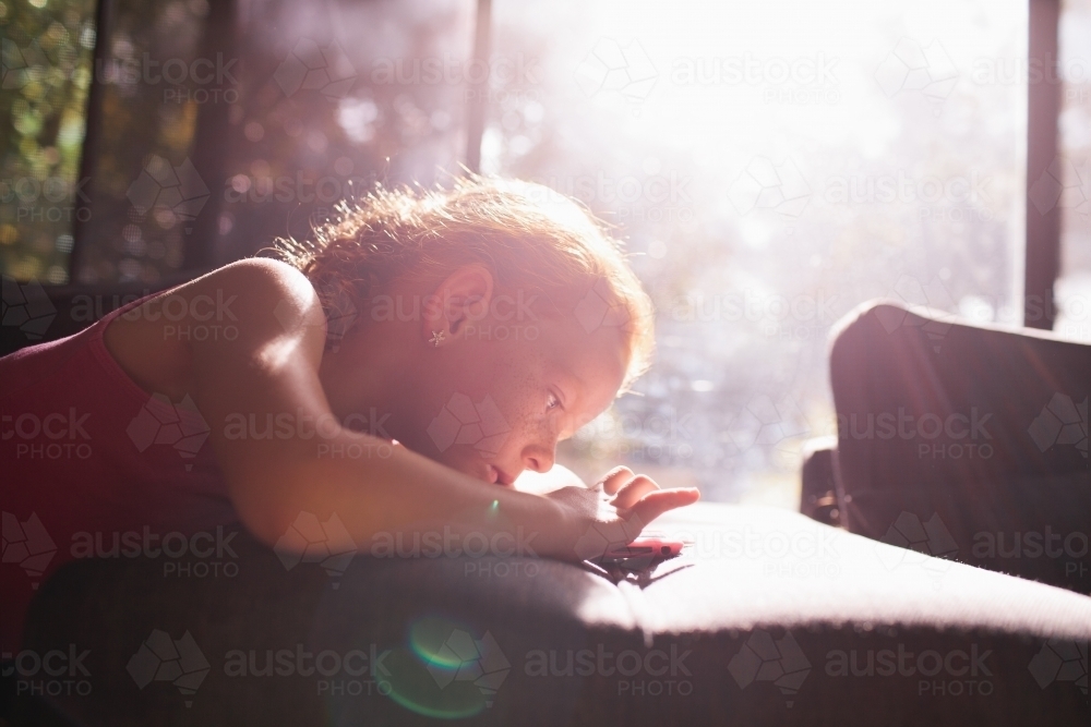 Young girl looking at a device - Australian Stock Image