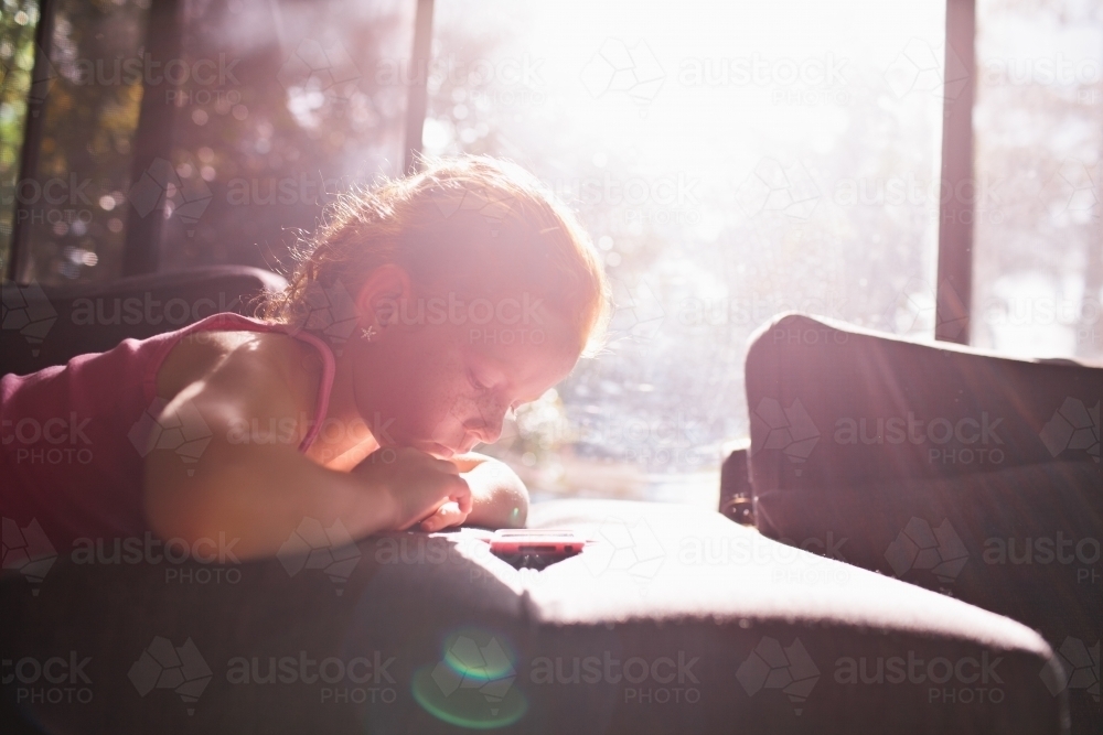Young girl looking at a device : Austockphoto Young girl looking at a device - Australian Stock Image