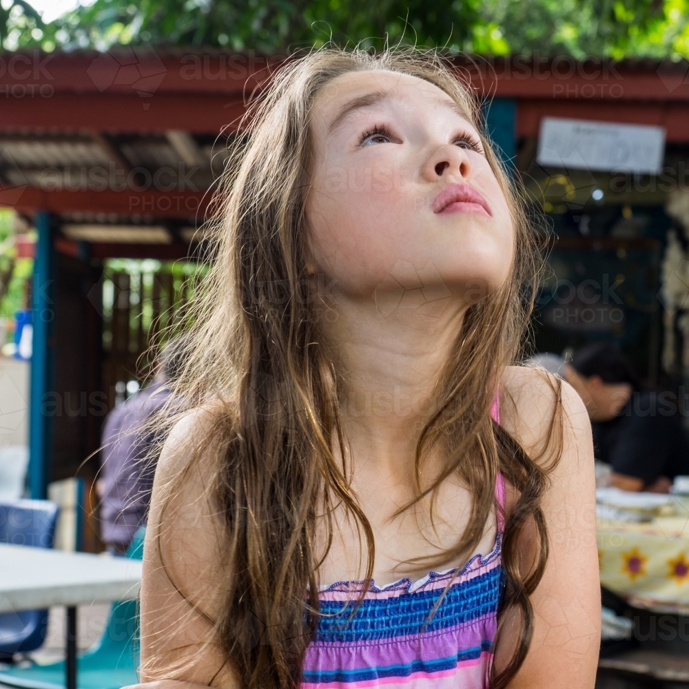 Young girl looking at something in the tree - Australian Stock Image