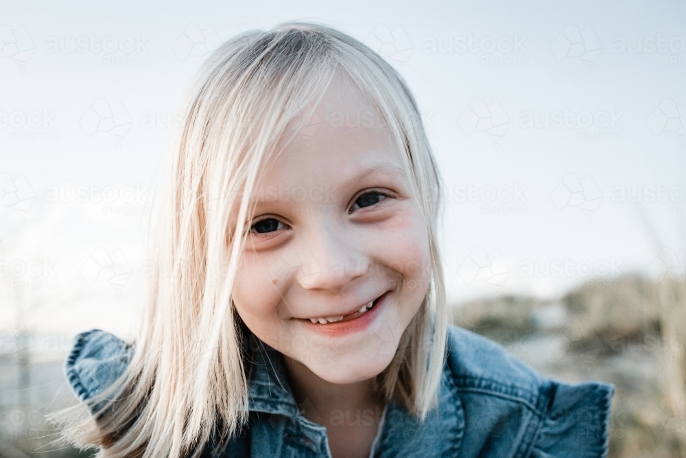 Young girl looking at the camera missing two front teeth - Australian Stock Image