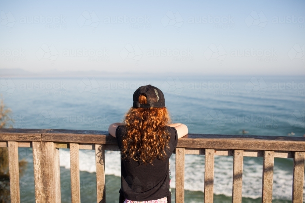 Young girl looking out at the beach from a lookout - Australian Stock Image