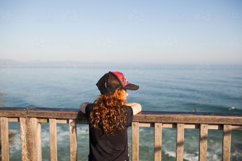 Young girl looking out at the beach from a lookout - Australian Stock Image