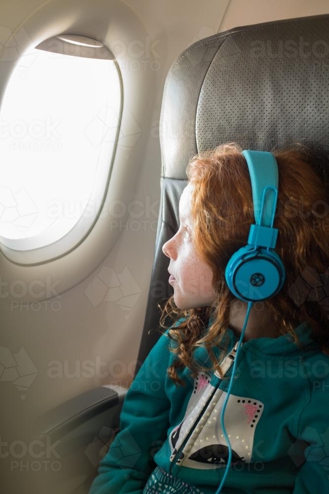 Young girl looking out of a passenger plane window - Australian Stock Image