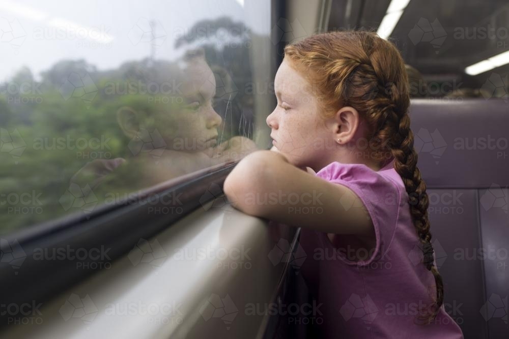 Young girl looking out the window of a train - Australian Stock Image