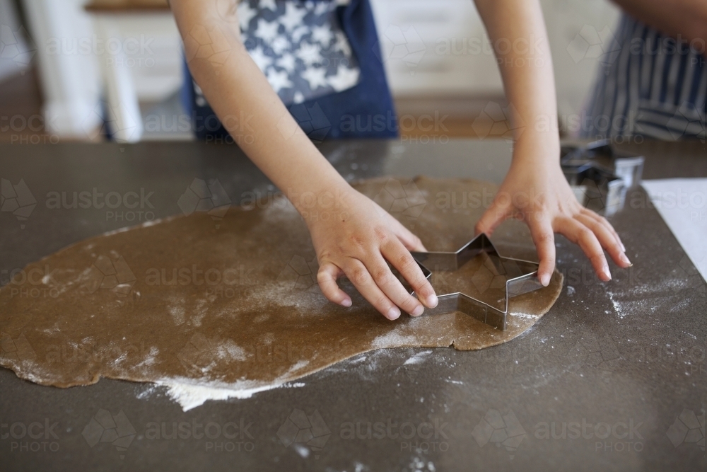 Young girl making gingerbread biscuits at home - Australian Stock Image