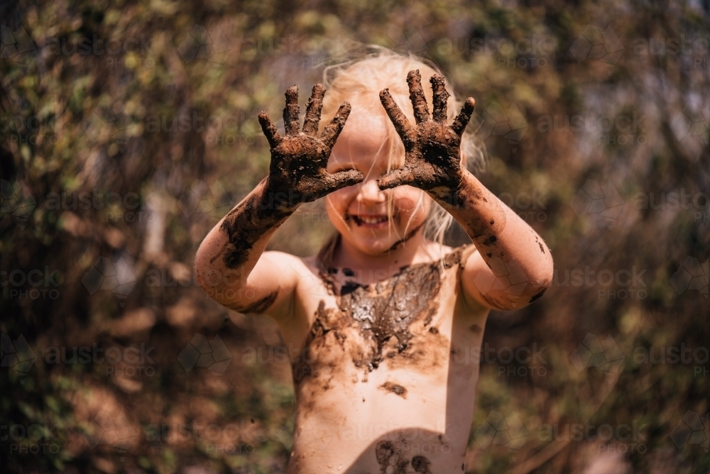 Young girl showing muddy hands - Australian Stock Image