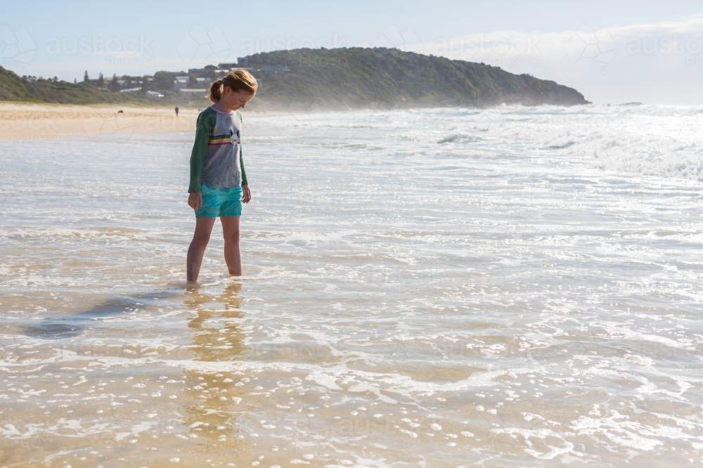 Image of Young girl on a beach looking at the sea - Austockphoto