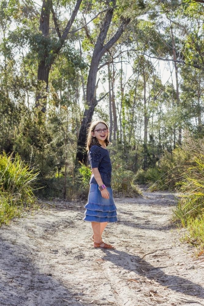 Young girl on sandy path in bushland - Australian Stock Image