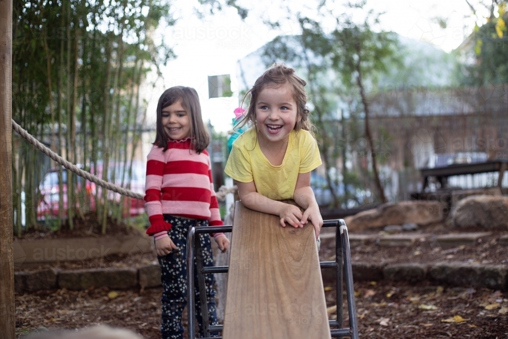 Young girl on wooden see-saw - Australian Stock Image