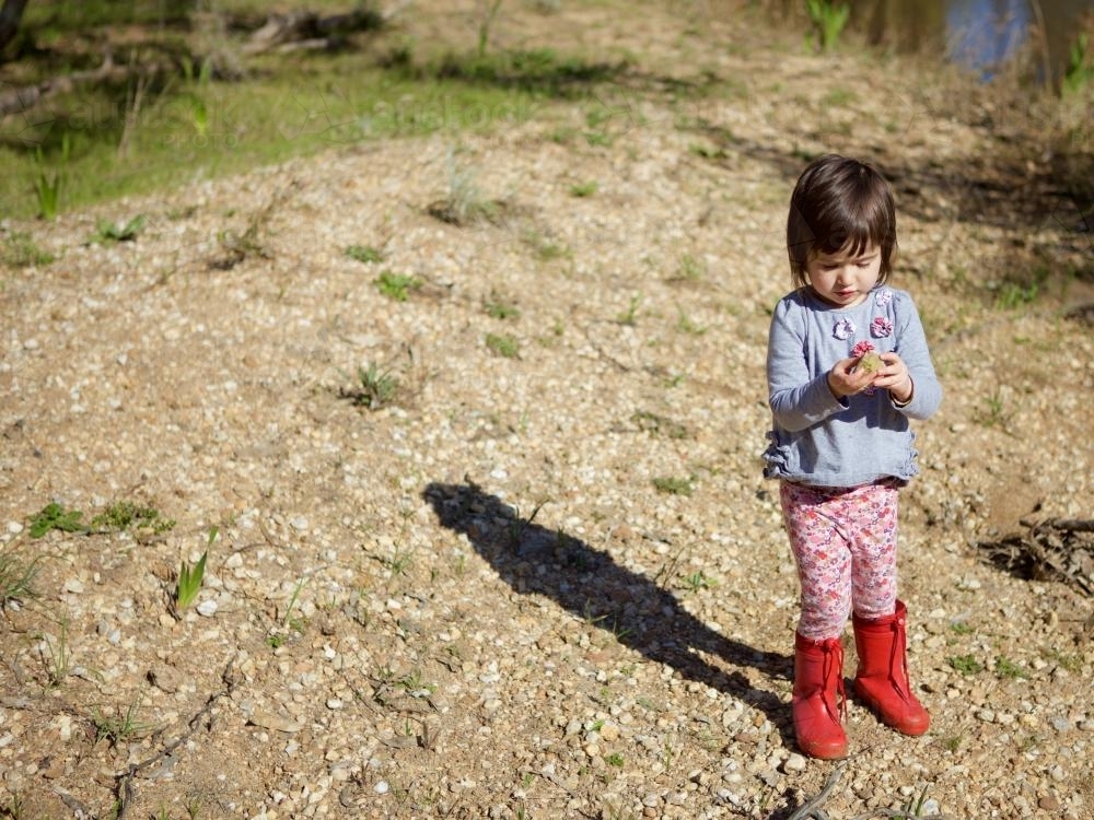 Young girl or child playing on a river bank - Australian Stock Image