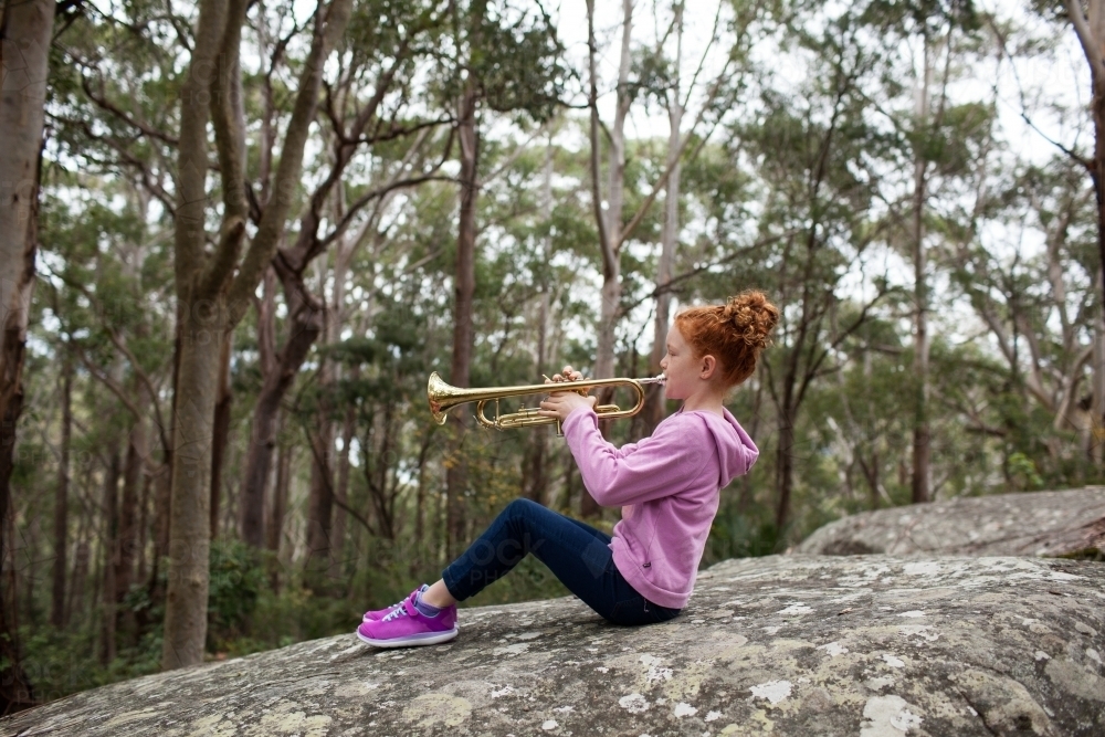 Young girl playing a trumpet outside - Australian Stock Image