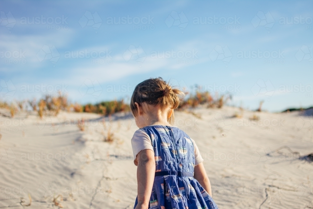 Young girl playing in sand dunes - Australian Stock Image