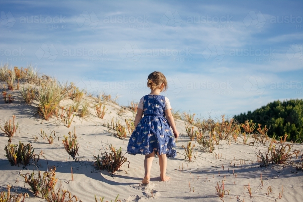 Young girl playing in sand dunes - Australian Stock Image