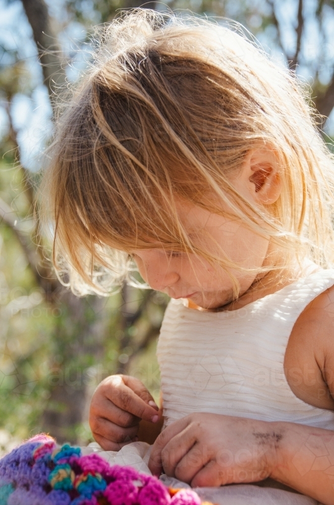 Young girl playing outdoors in a white dress - Australian Stock Image