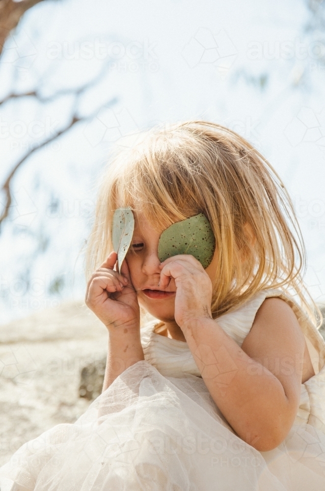 Young girl playing with gumleaves - Australian Stock Image