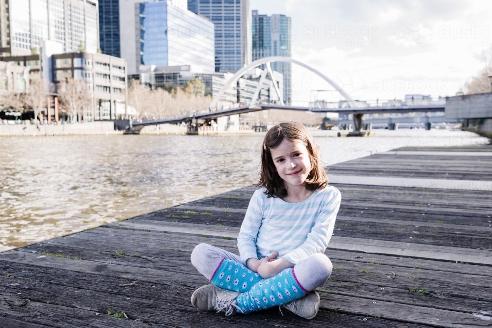 Young girl poses for a portrait while sightseeing by the Yarra River in Melbourne City - Australian Stock Image
