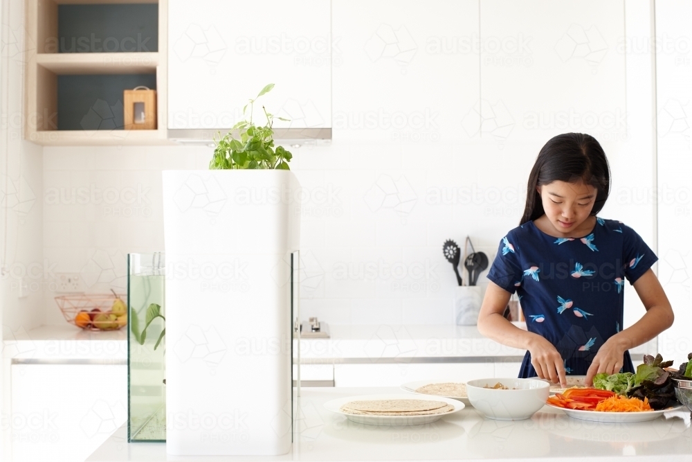 Young girl preparing healthy lunch in kitchen - Australian Stock Image