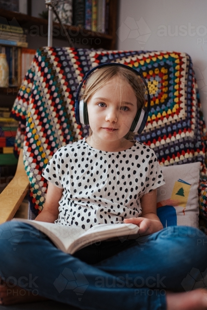 Young girl reading a book at home - Australian Stock Image