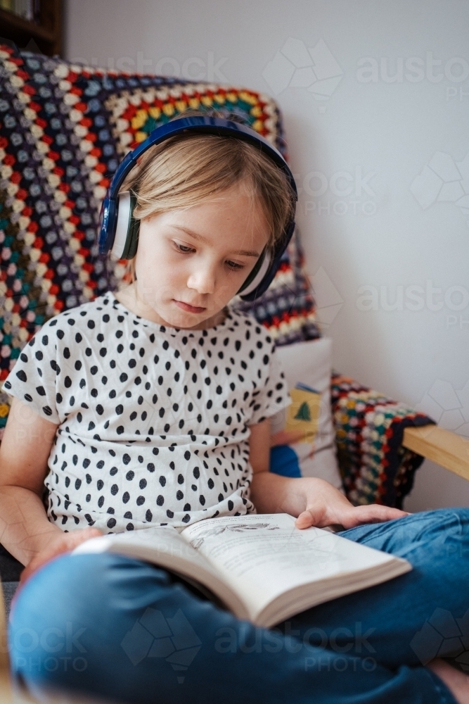 Young girl reading a book at home - Australian Stock Image