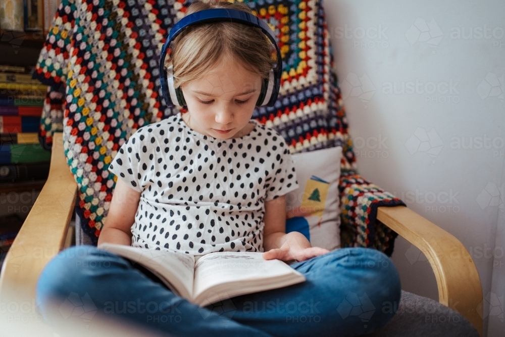 Young girl reading a book at home - Australian Stock Image