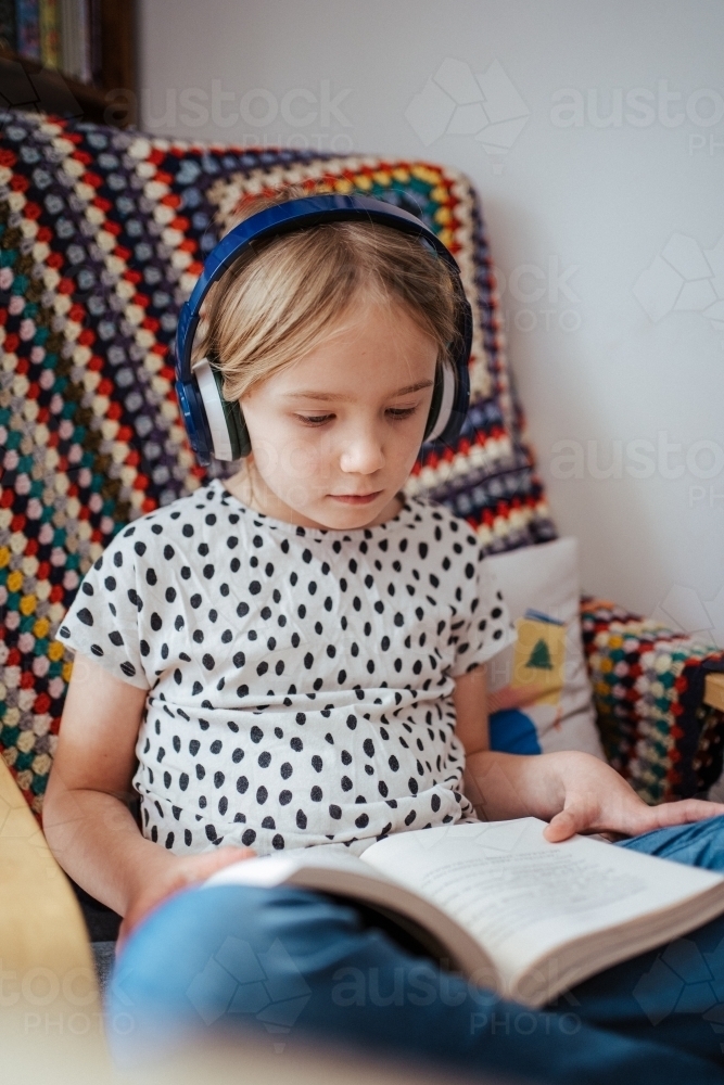 Young girl reading a book at home - Australian Stock Image