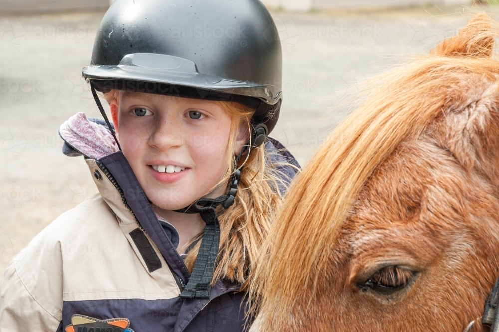 young girl rider in a helmet and her horse - Australian Stock Image