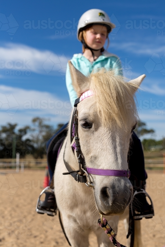 Young girl riding a grey horse - Australian Stock Image