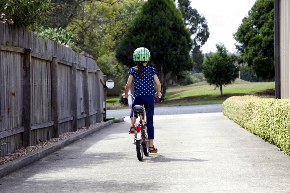 Young girl riding bike from behind - Australian Stock Image