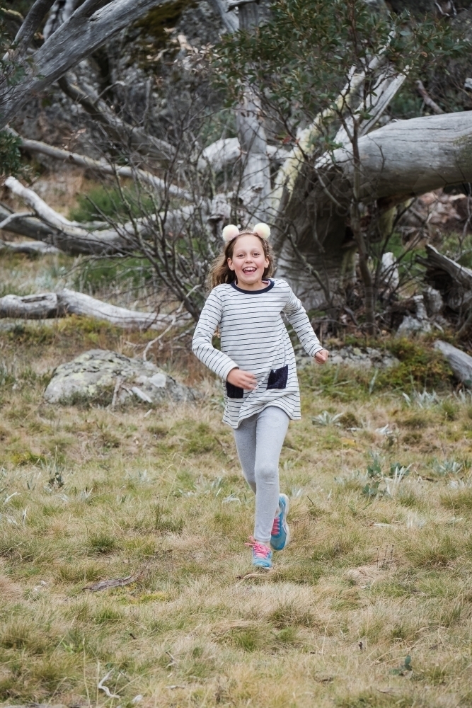 Young girl running in the country side. - Australian Stock Image