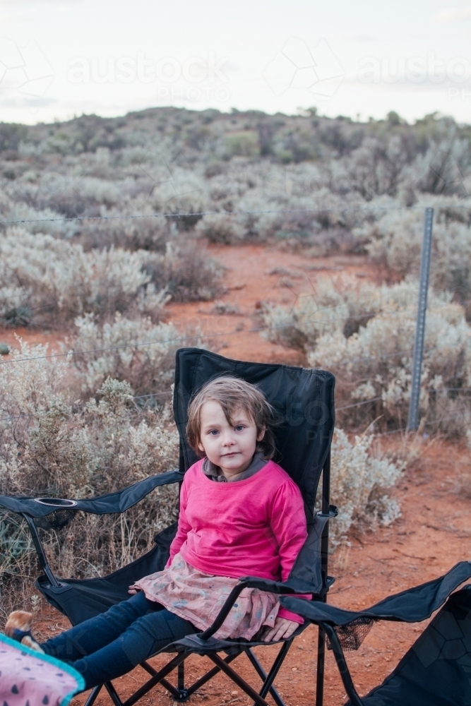 Young girl sitting in camper chair - Australian Stock Image