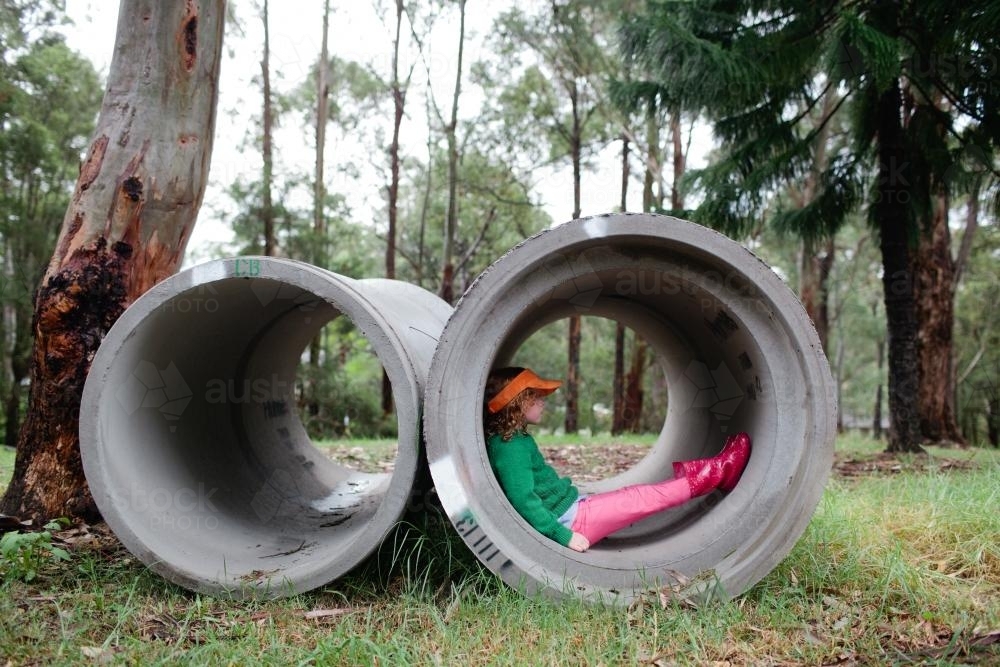 Young girl, sitting in drainage pipes - Australian Stock Image