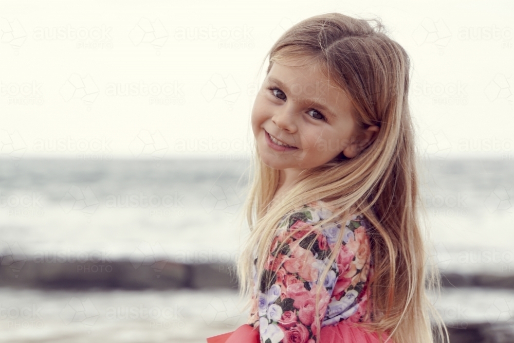 Young girl smiling back at camera - Australian Stock Image