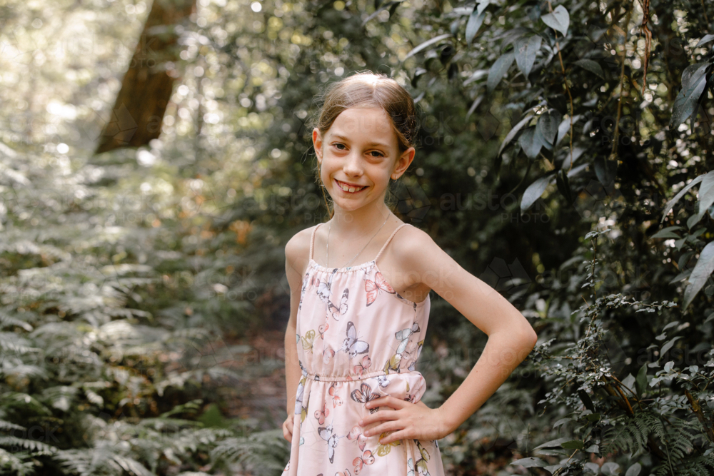 Young girl standing in the forest with hands on her waist. - Australian Stock Image