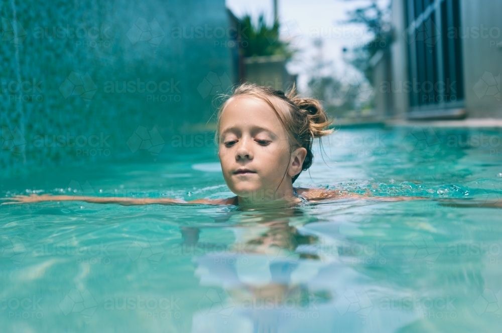young girl swimming in the pool  - Australian Stock Image