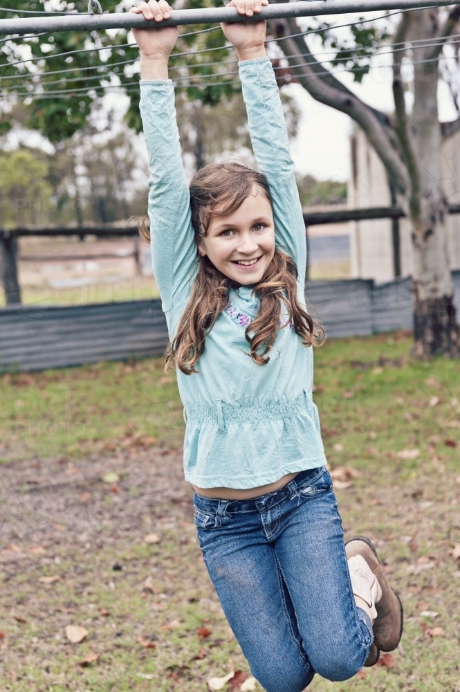 Young girl swinging on the clothesline - Australian Stock Image