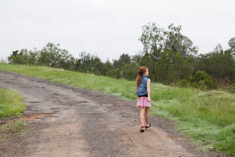 Young girl walking along a dirt road - Australian Stock Image