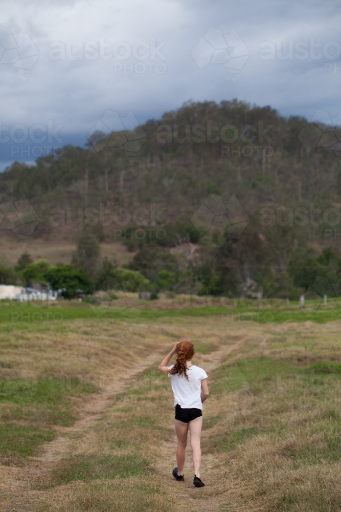 Young girl walking along a dirt track - Australian Stock Image
