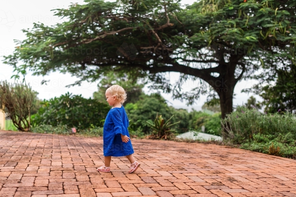 Young girl walking in a backyard - Australian Stock Image