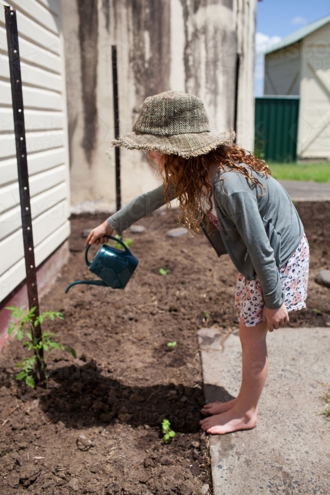 Young girl watering a garden - Australian Stock Image