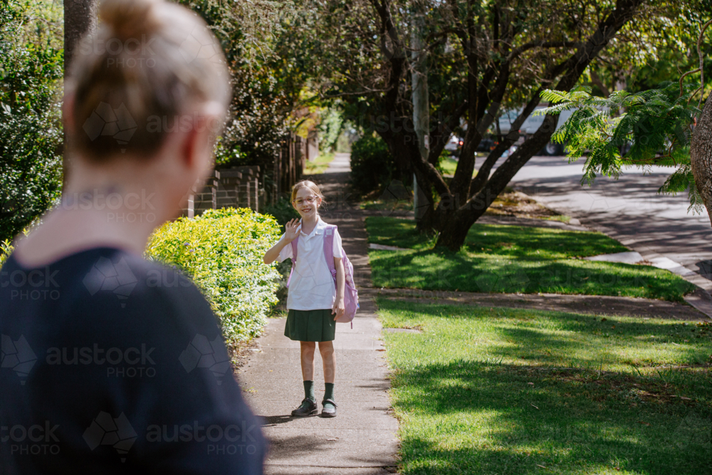 Young girl waving goodbye to mum - Australian Stock Image