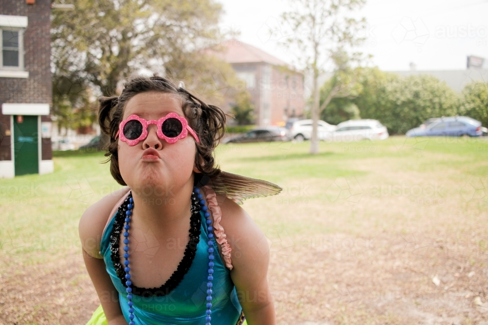 Young girl wearing bright blue leotard top posing outdoors - Australian Stock Image