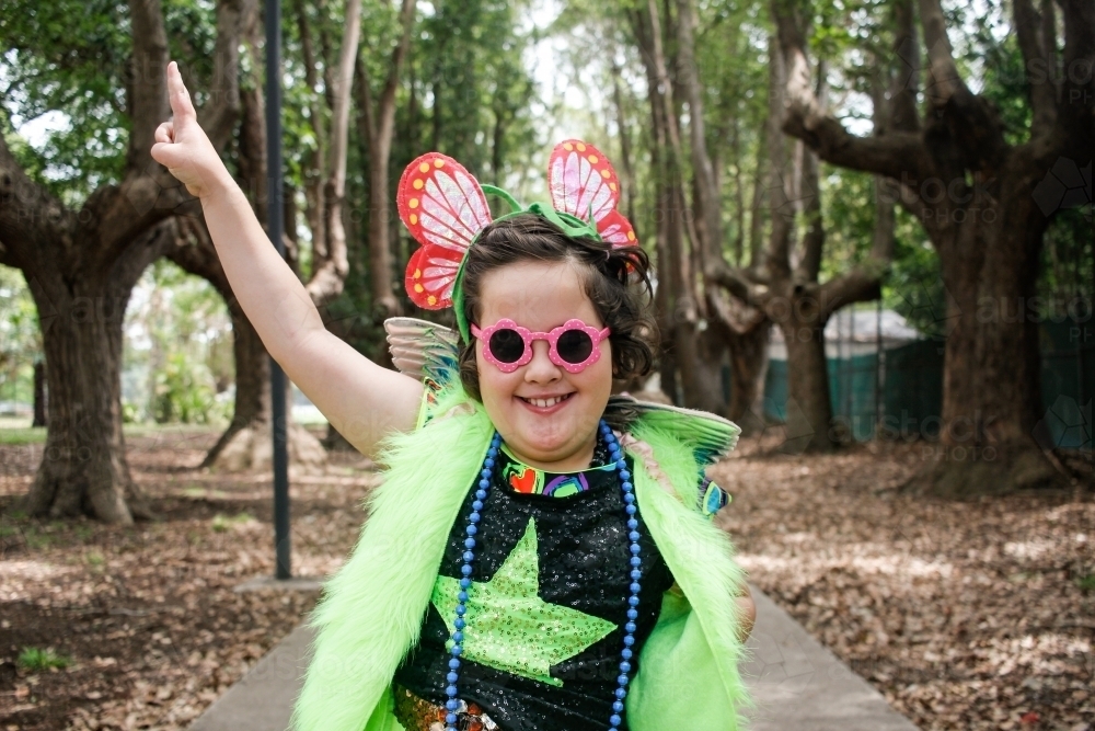 Young girl wearing crazy fluoro dress-up in urban park - Australian Stock Image