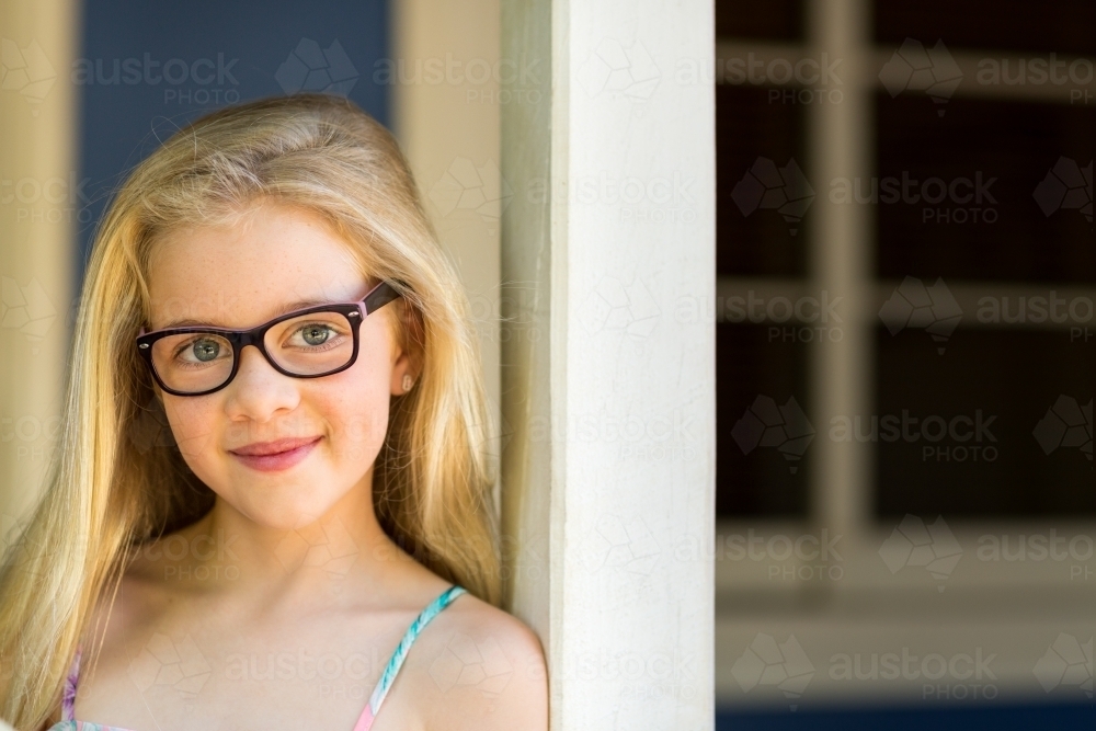 Young girl wearing glasses, head and shoulders - Australian Stock Image
