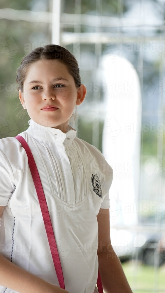 Young girl wearing high-collared shirt with pink strap on shoulder - Australian Stock Image
