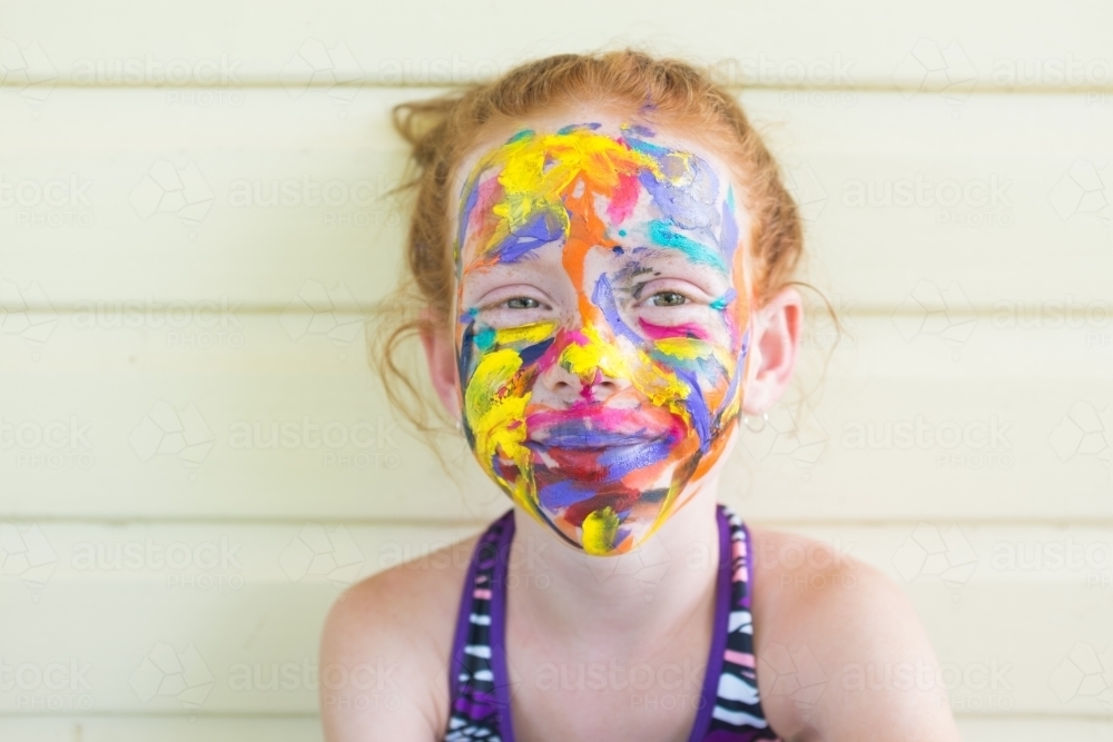 Young girl with a brightly painted face - Australian Stock Image