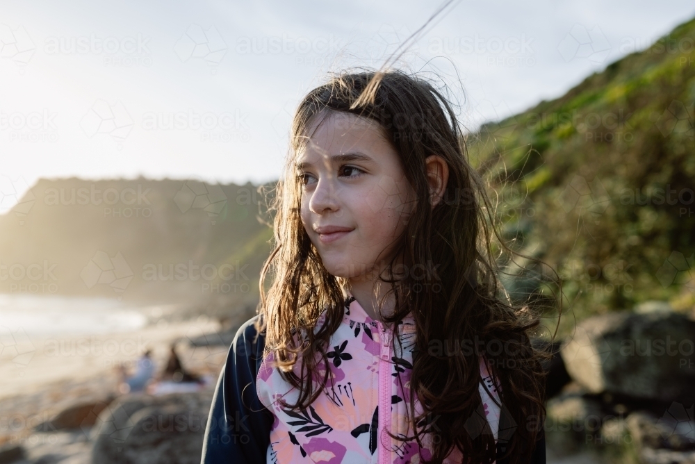 Young girl with a sand speckled face on the beach at sunset; Bushrangers Bay, Cape Schanck - Australian Stock Image